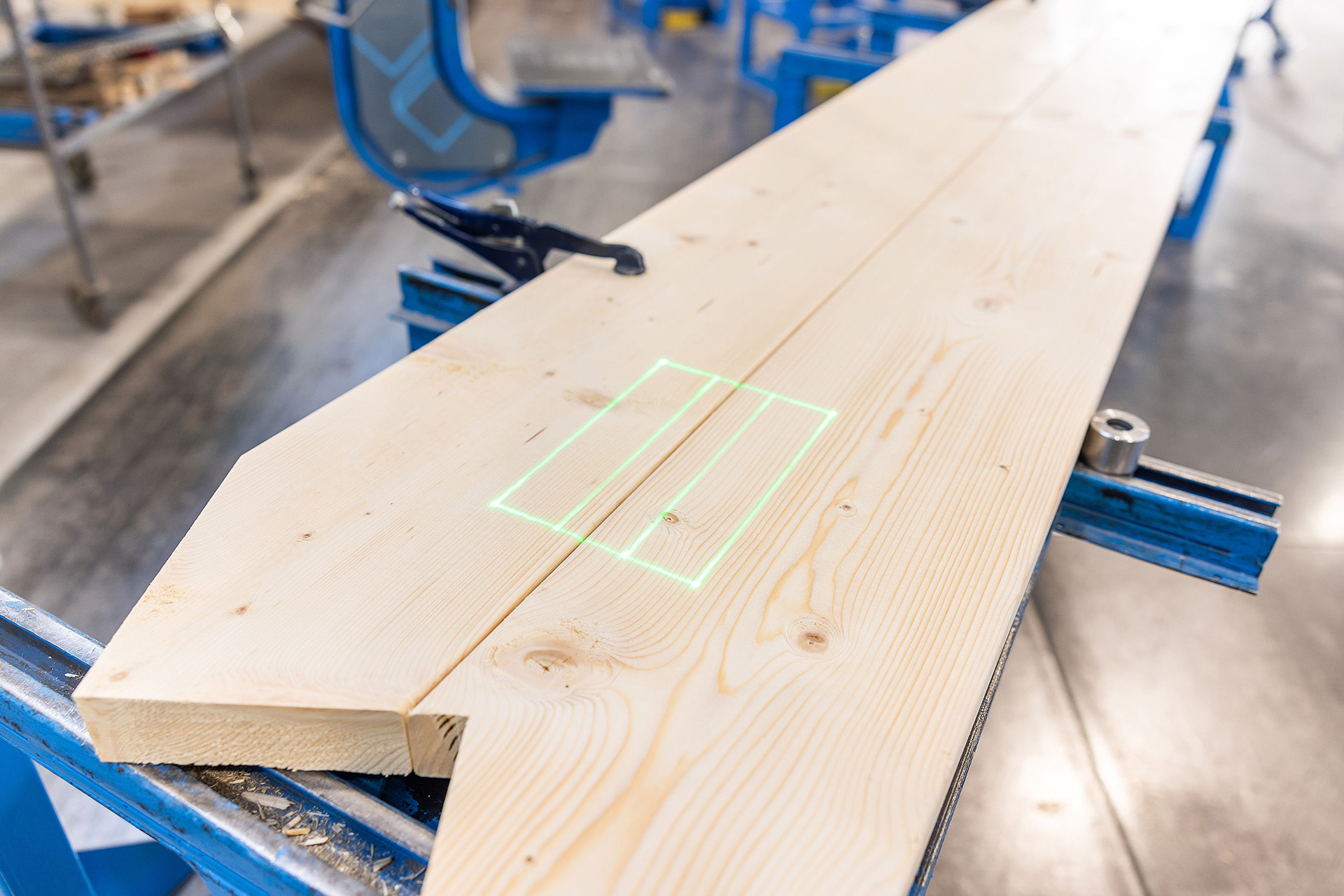 Zielony kontur laserowy rzutowany na deskę wiązara na stole Randek